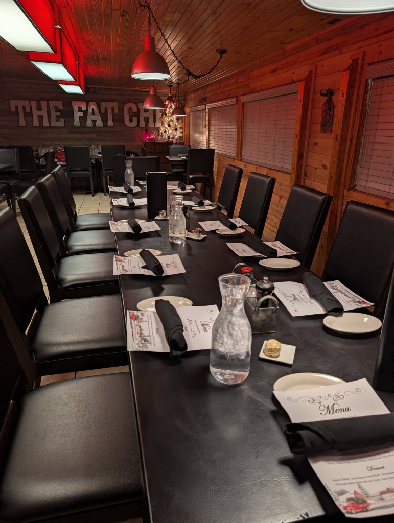 The Fat Chef dining room — rustic log cabin interior with elegant table settings